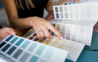 Close-up of two women choosing samples of wall paint- Best Paint Colors for your Business