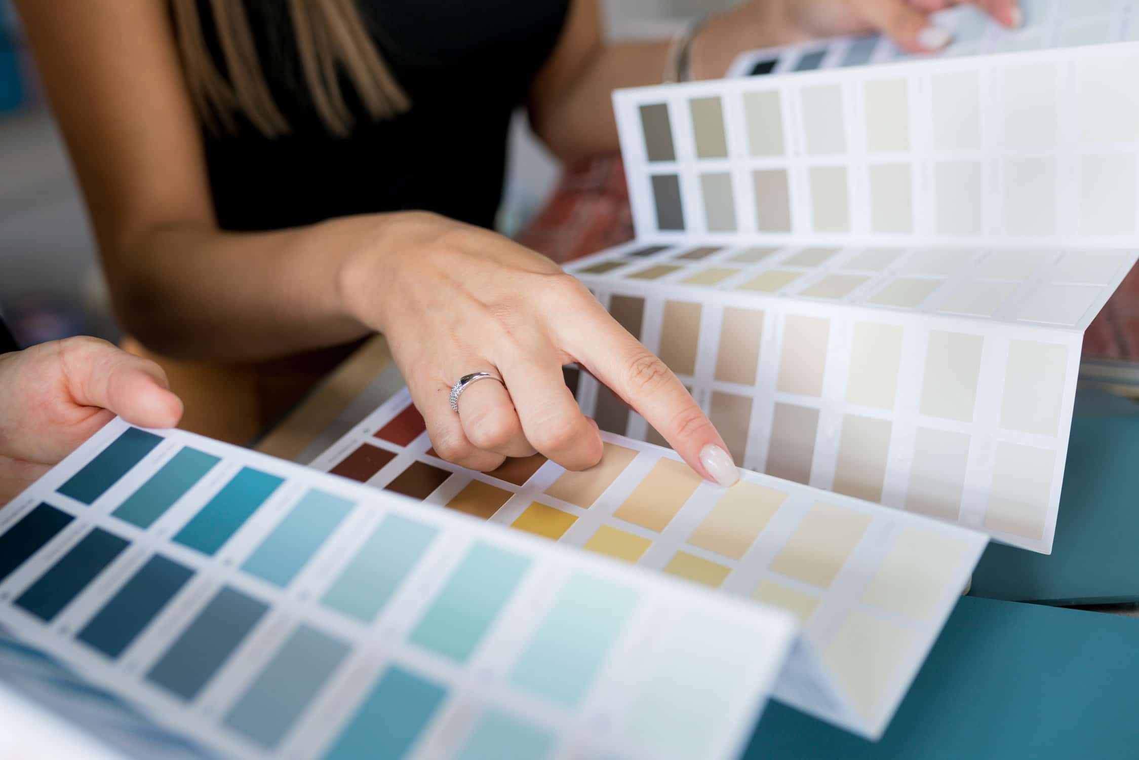 Close-up of two women choosing samples of wall paint- Best Paint Colors for your Business