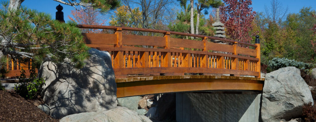 a newly painted wooden bridge over a rock