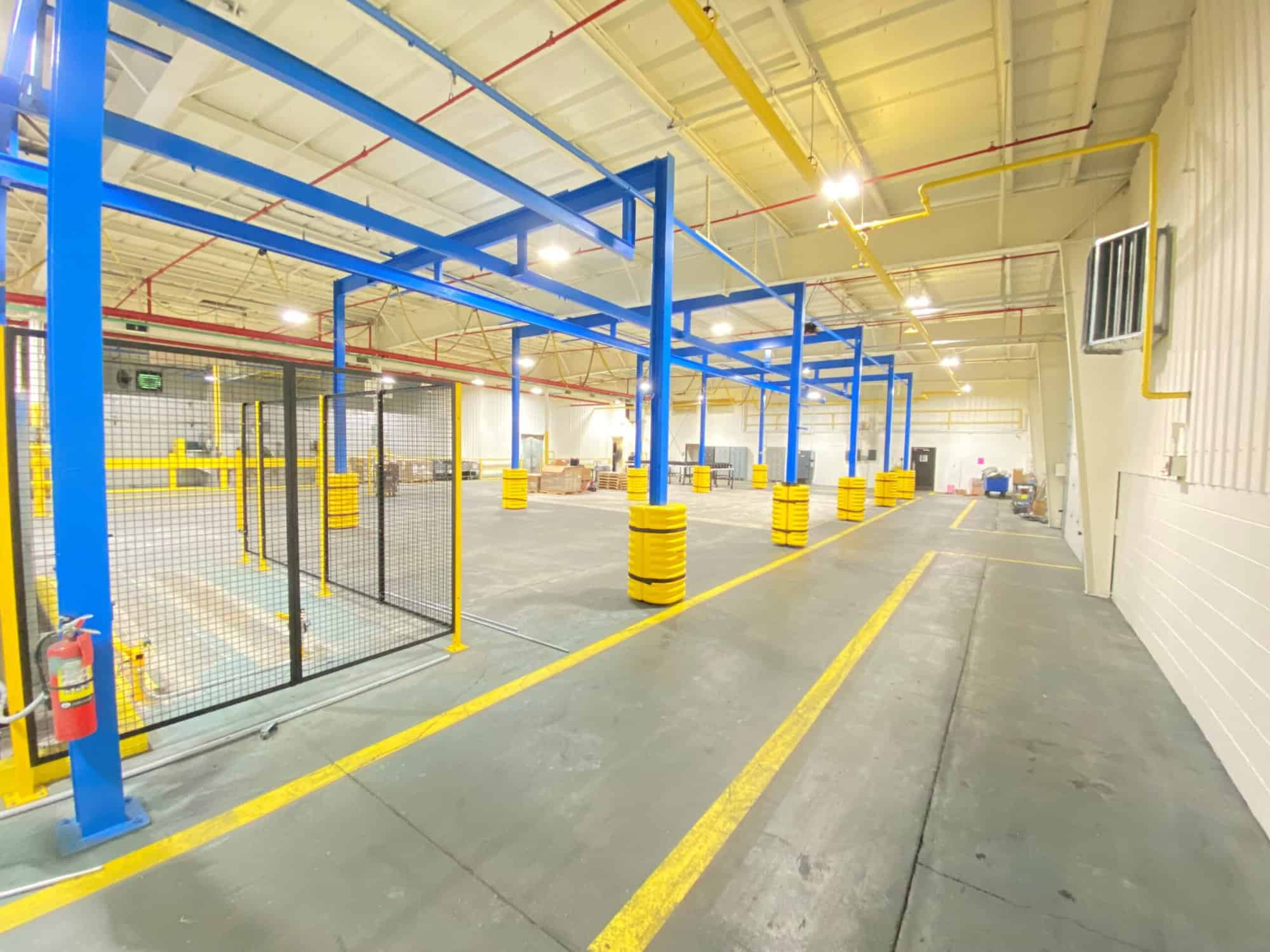 a large warehouse with blue poles and yellow poles