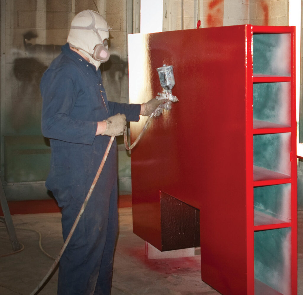 a painter wearing a protective gear painting a red shelf
