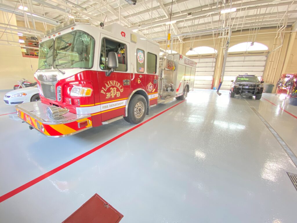 a fire truck and cars inside a fire station